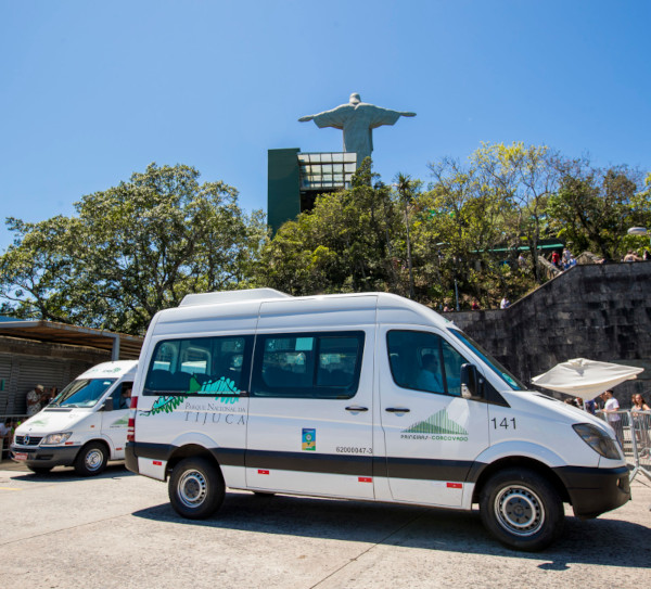 Vans oficiais de acesso ao Corcovado com o Cristo Redentor ao fundo